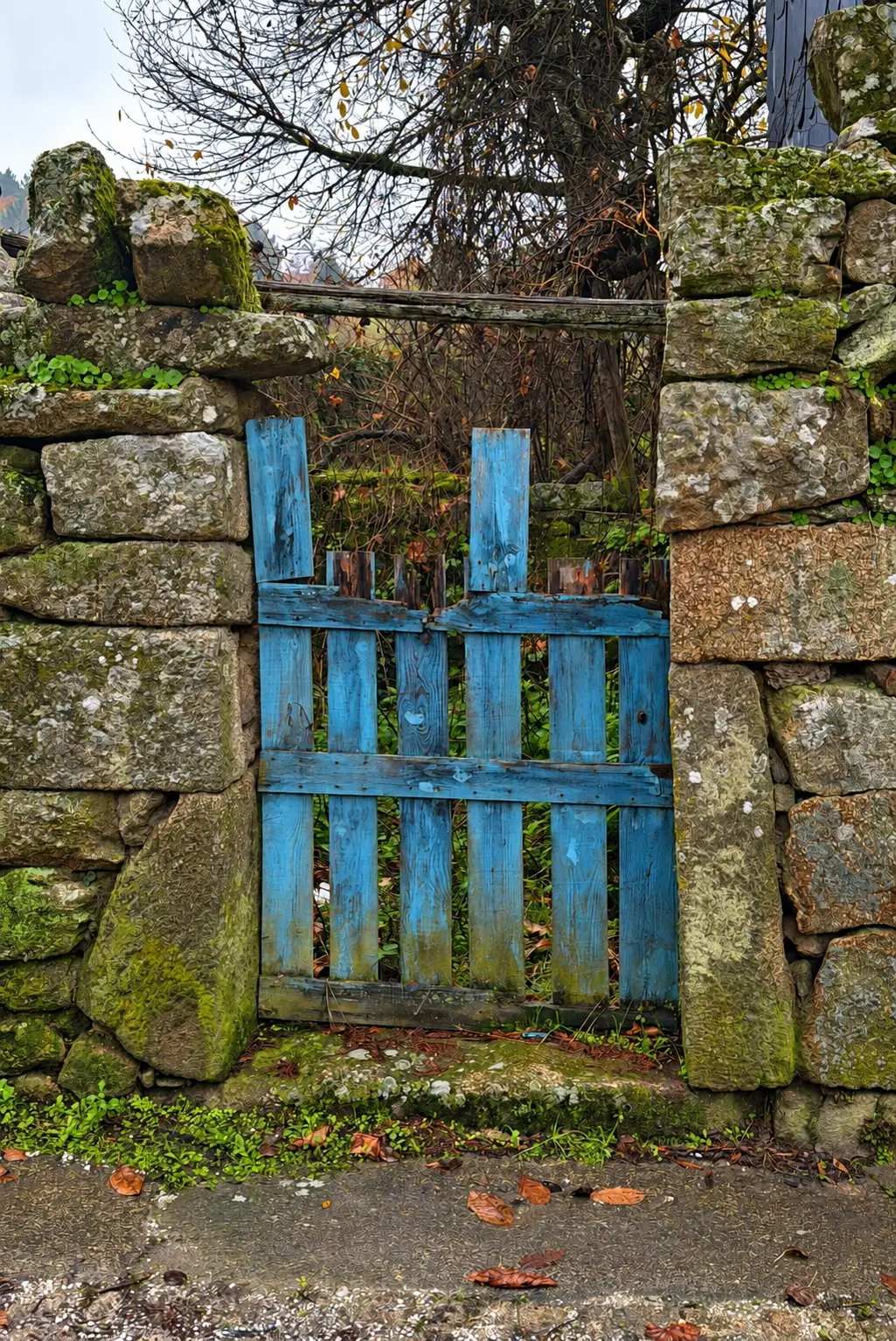 Portão azul em muro de pedra